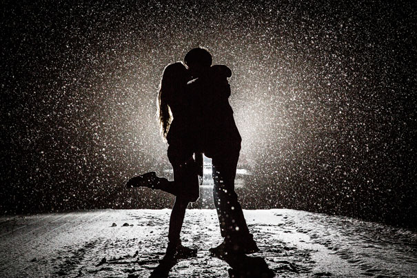 A couple hugging in the snow under a spotlight, creating a happy and romantic scene. A couple hugging in the snow under a spotlight, creating a happy and romantic scene.