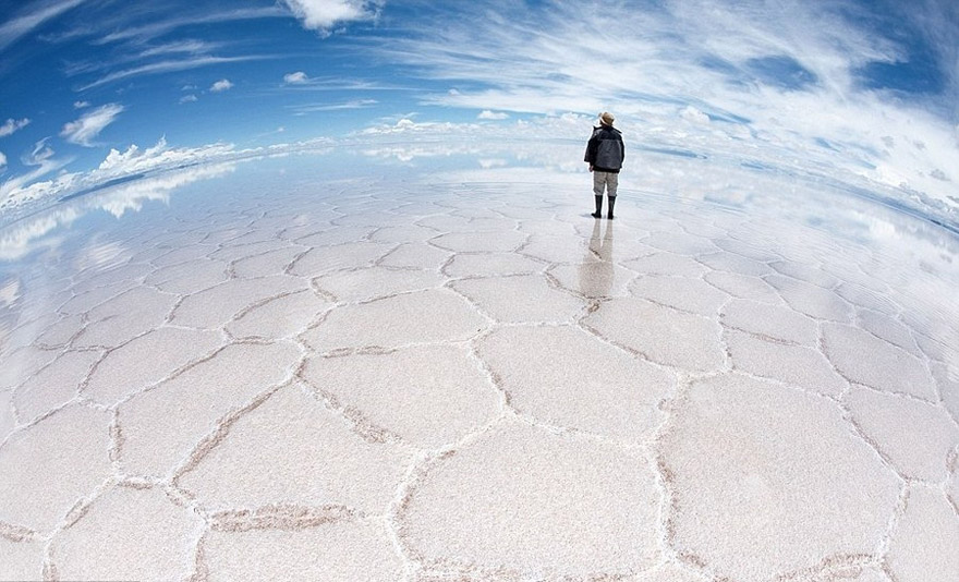 A person standing on the reflective surface of Salar de Uyuni, one of the unbelievable places to visit before you die. A person standing on the reflective surface of Salar de Uyuni, one of the unbelievable places to visit before you die.